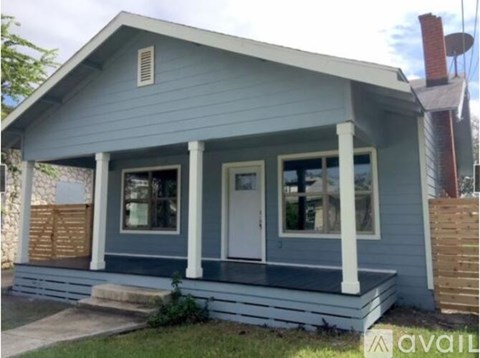 A small blue house with a porch and a white door.