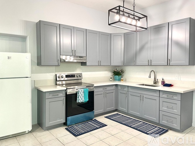 A kitchen with grey cabinets and a white fridge.