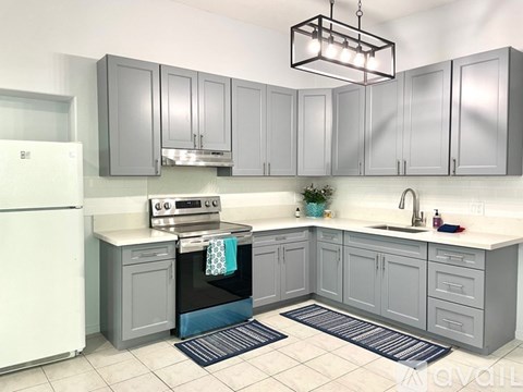 A kitchen with grey cabinets and a white fridge.
