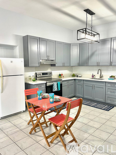 A kitchen with a table and chairs in front of it.