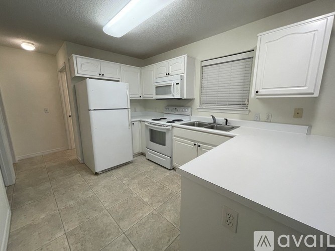 A kitchen with white appliances and cabinets.
