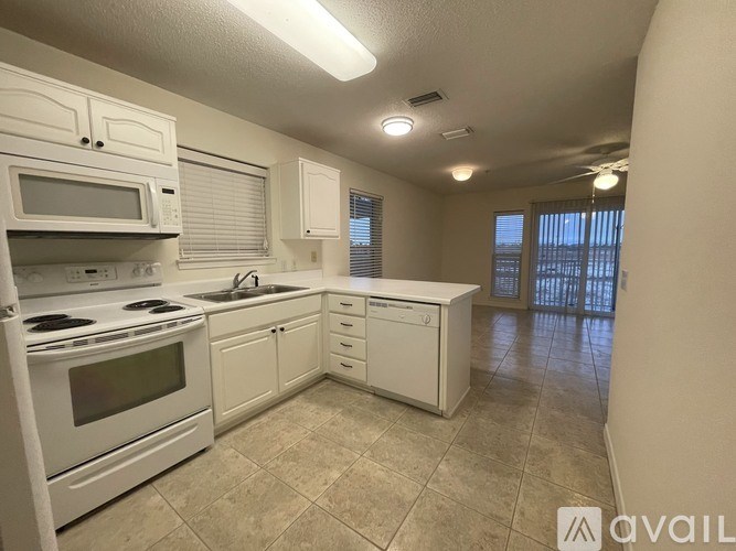 A kitchen with white appliances and cabinets.