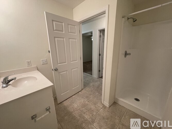 A bathroom with a sink, door, and shower.