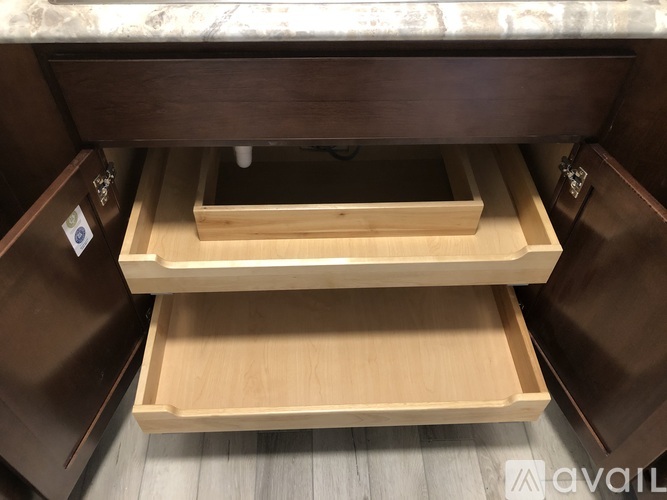 A wooden drawer with a lock is open.