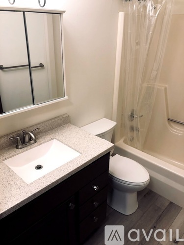 A bathroom with a sink, toilet, and shower.