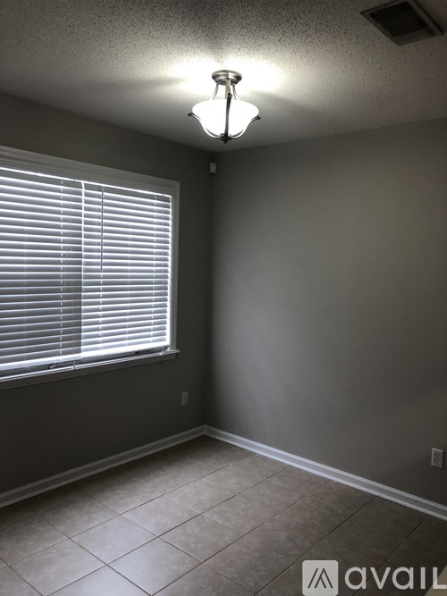 A room with a window and a light fixture on the ceiling.