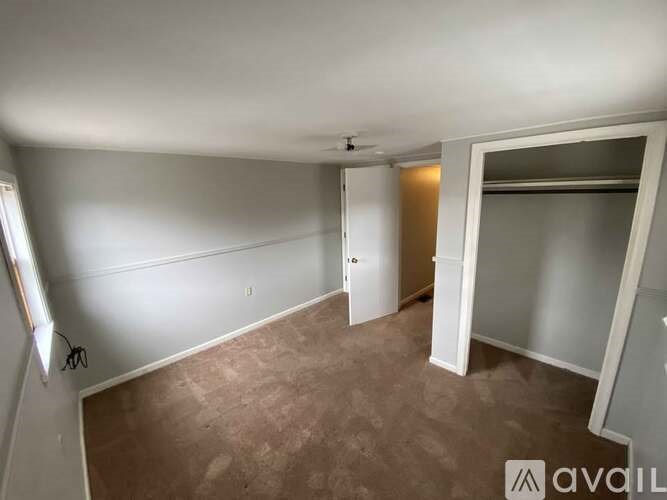 A room with a brown carpet and white walls.
