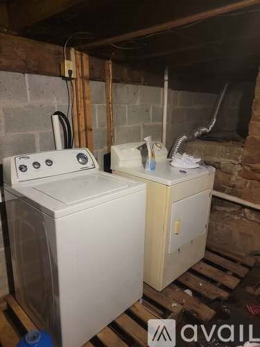 A white washing machine and dryer in a basement.