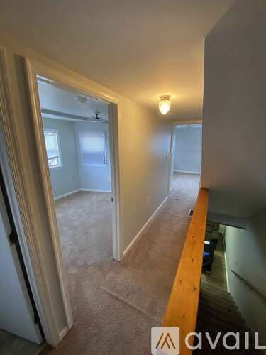 A hallway with a carpeted floor and a yellow line on the wall.