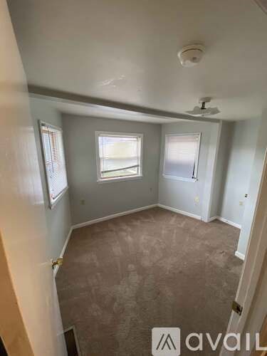 A room with a carpeted floor and a window.