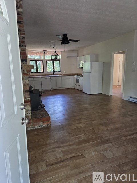 A living room with a brick column and a ceiling fan.