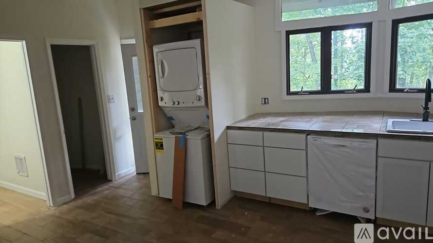 A kitchen with a sink, cabinets, and a window.