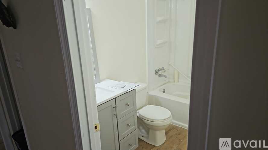 A white toilet sits in a bathroom next to a white cabinet.