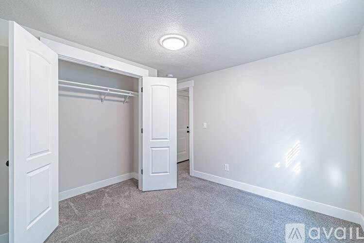 A room with a carpeted floor and a white door.