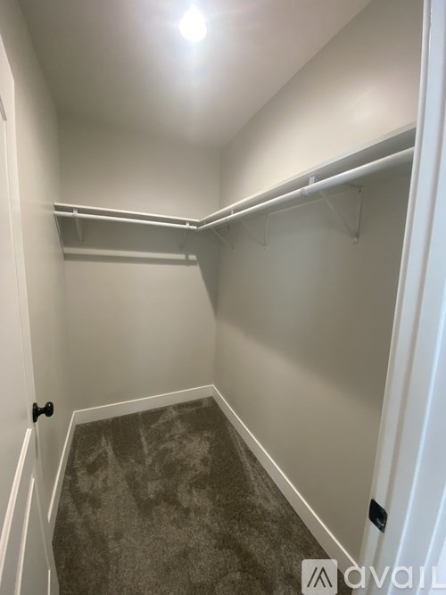 A small, empty room with a carpeted floor and white walls.