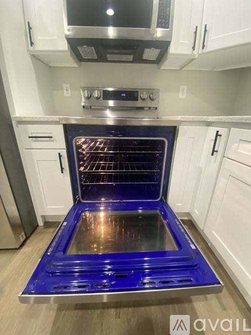 A blue oven with the door open in a kitchen.