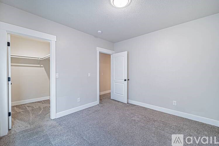 A long hallway with white walls and a carpeted floor.
