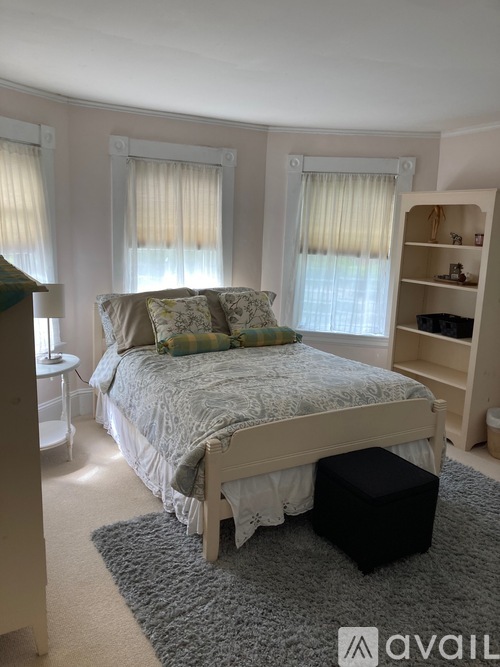 A bedroom with a large bed and a bookshelf.