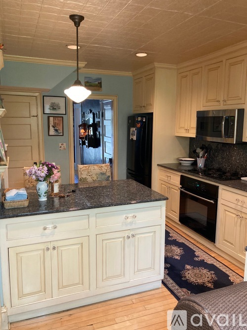 A kitchen with wooden cabinets and a black countertop.