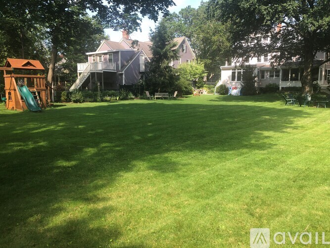 A backyard with a green lawn and a playground.