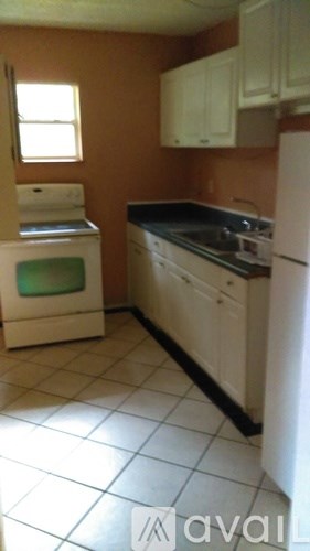 A kitchen with white appliances and brown walls.