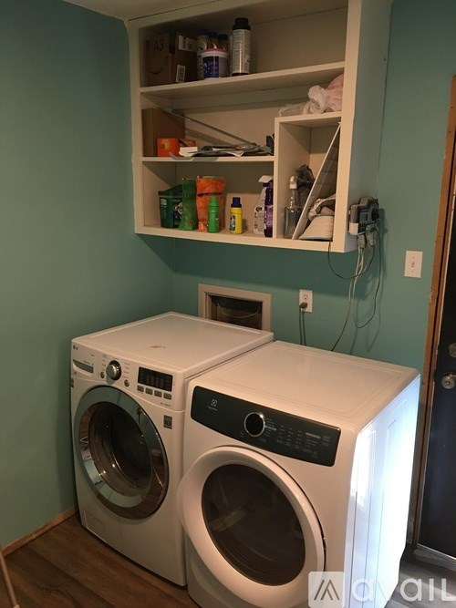 A white washing machine and dryer in a laundry room.