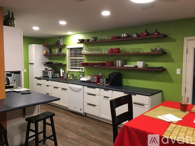 A kitchen with green walls and white appliances.