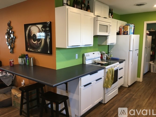 A kitchen with white cabinets and a black countertop.
