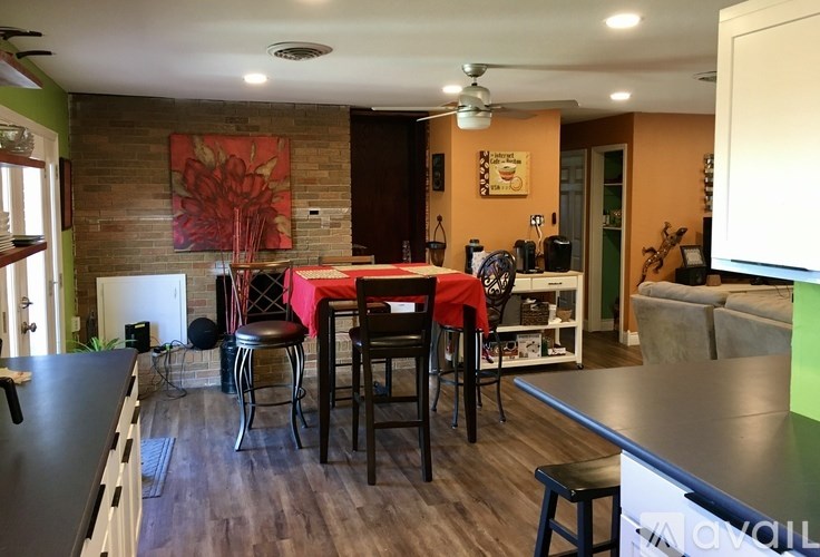 A kitchen with a dining table and chairs in the middle of the room.