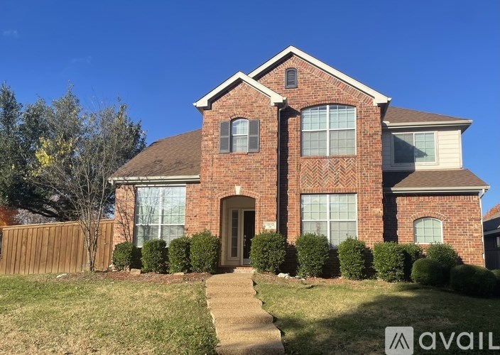 A brick house with a brown door and windows.