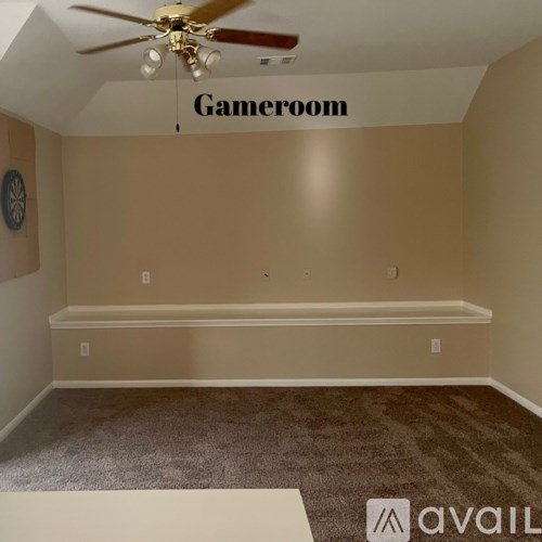 A room with a carpeted floor and a ceiling fan with a light fixture.