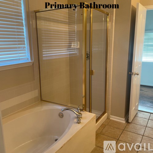 A bathroom with a tub and a glass door.
