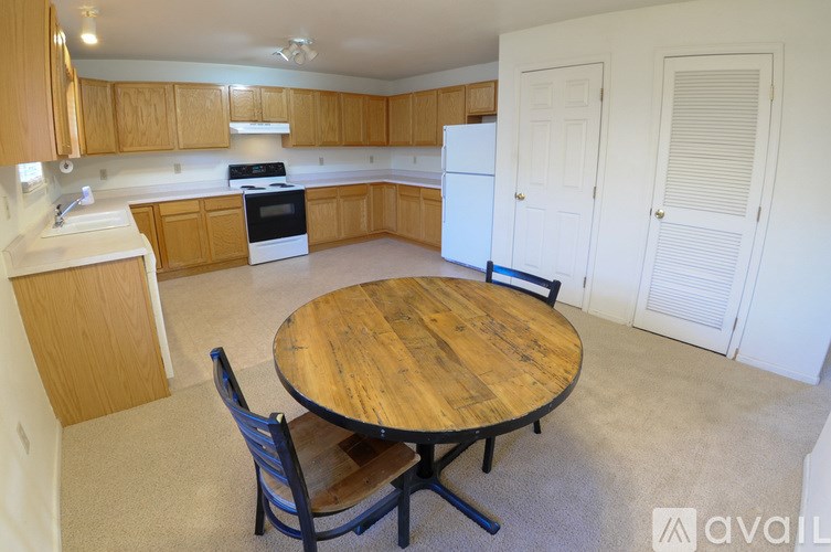 A kitchen with a table and chairs in the middle of the room.
