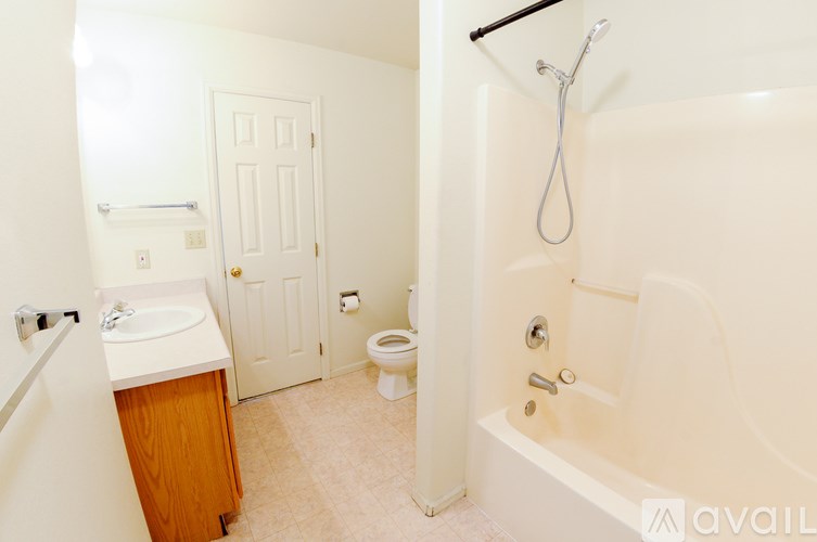 A white bathroom with a toilet, sink, and bathtub.