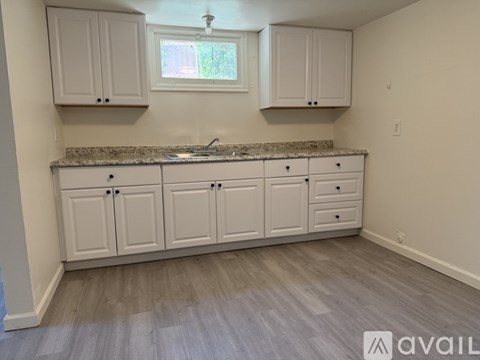 A kitchen with white cabinets and a granite countertop.