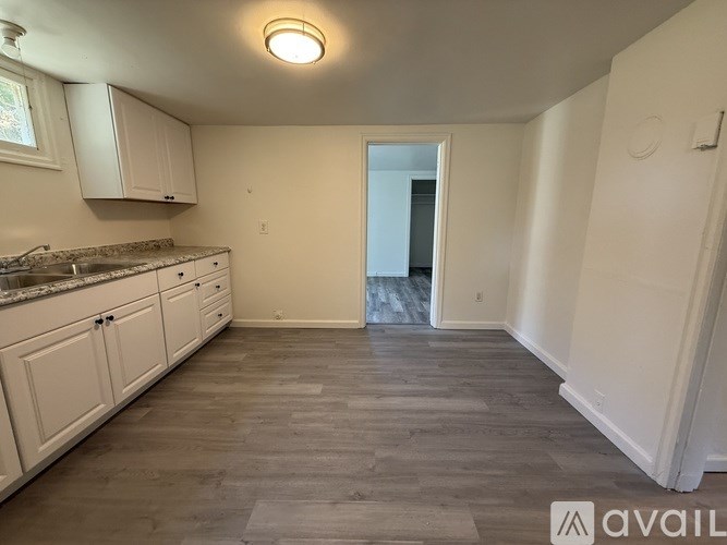 A kitchen with white cabinets and a countertop is available for rent.