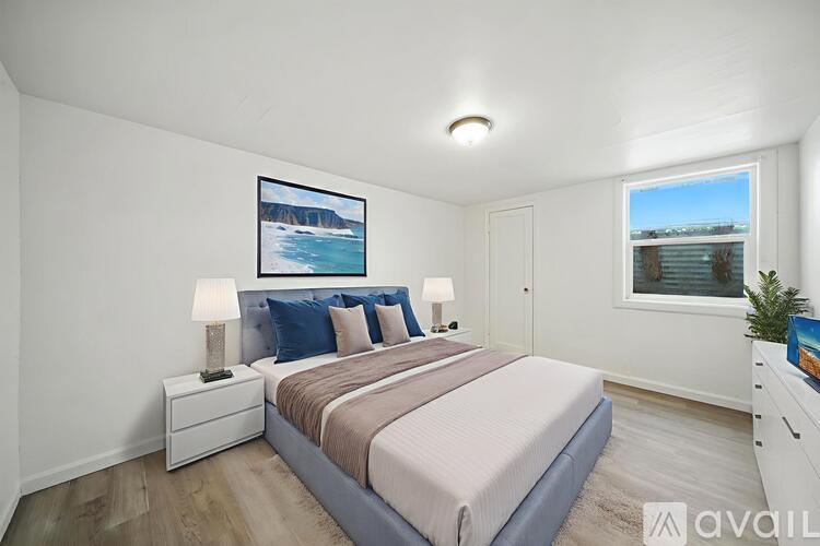 A room with wooden flooring and a window showing an outdoor view.