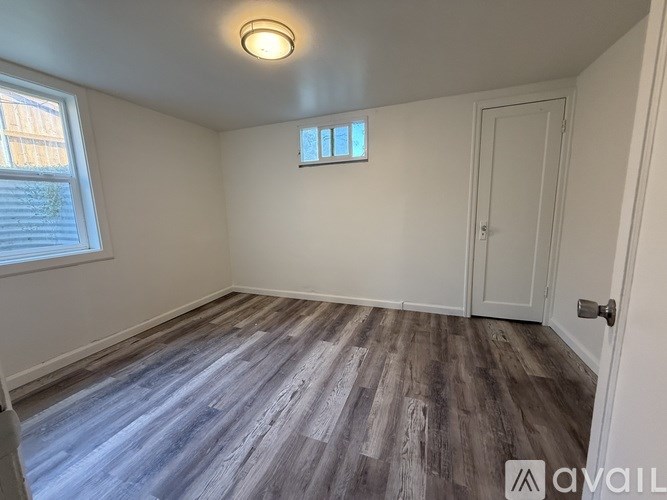 A room with a wooden floor and a white door.