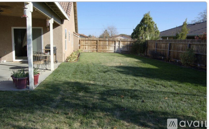 A backyard with a fence and a house.