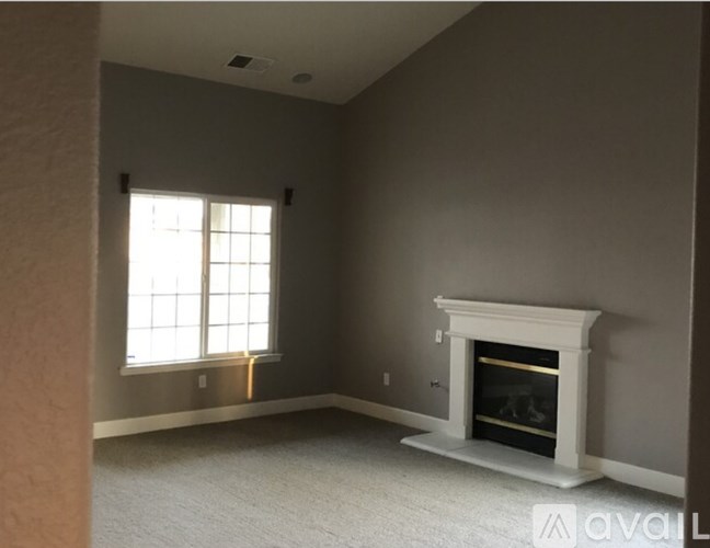 A living room with a fireplace and a window.