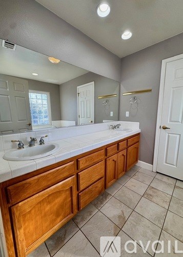 A bathroom with a double sink vanity and a large mirror.