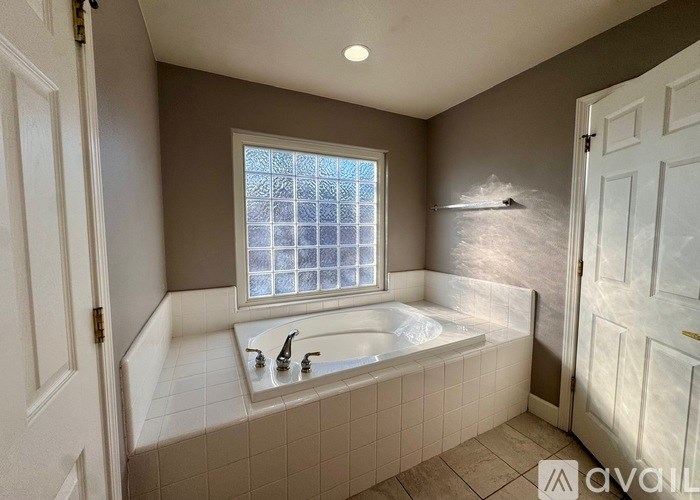 A bathroom with a large tub and a window.