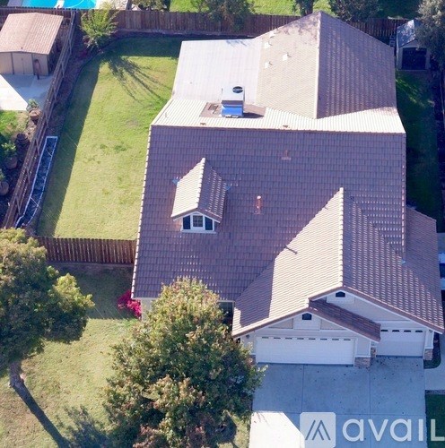 A house with a brown roof and a white garage.