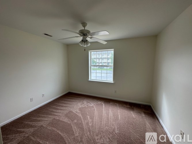 A room with a ceiling fan and a window.