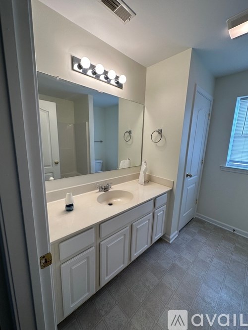 A bathroom with a double sink vanity and a mirror above it.