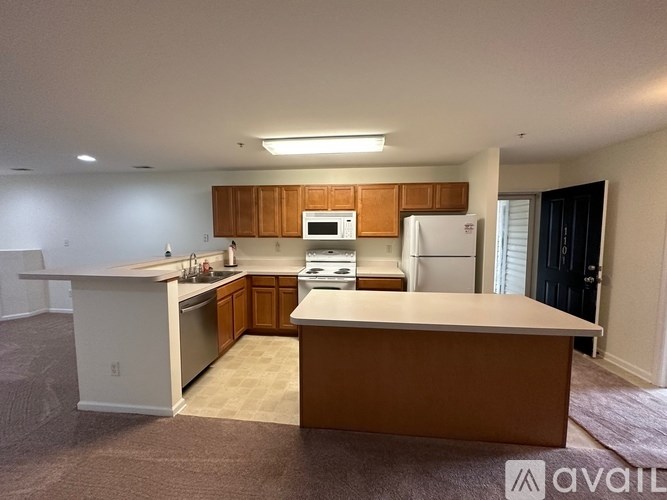 A kitchen with brown cabinets and a white refrigerator.