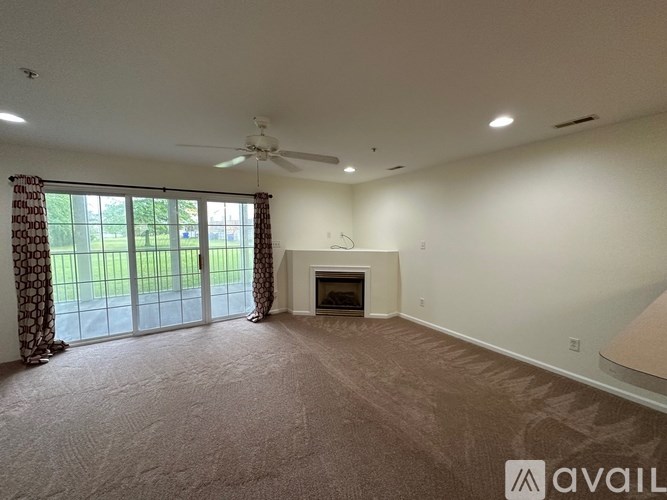 A living room with a fireplace and a sliding glass door.