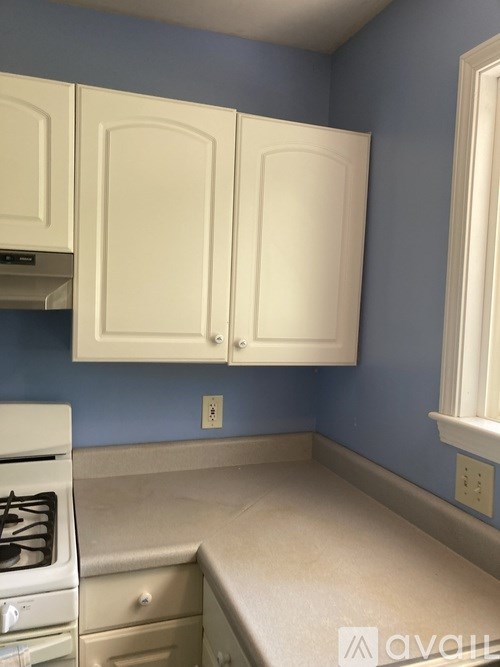 A kitchen with white cabinets and a stove top oven.