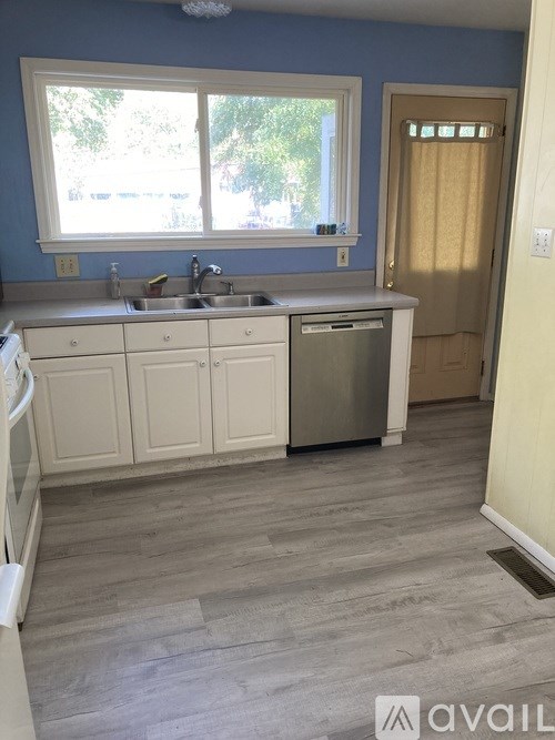 A kitchen with blue walls and white cabinets.