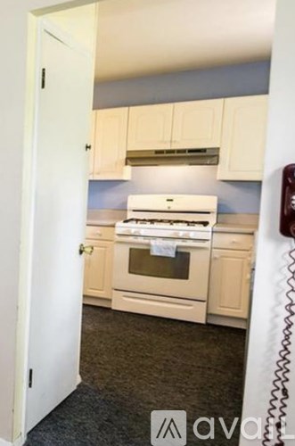 A kitchen with a white oven and cabinets.